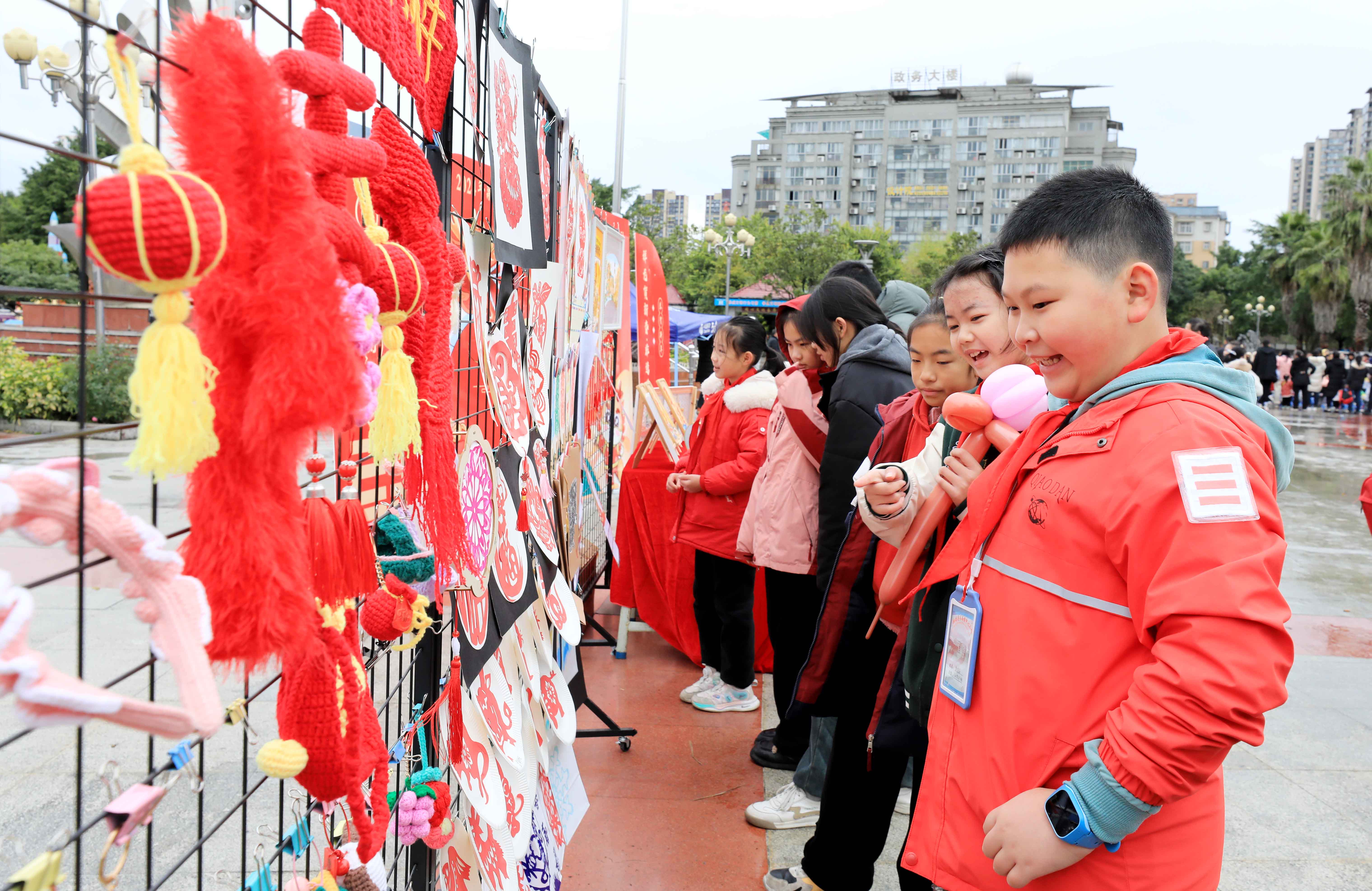 圖7：1月20日，在廣西柳州市融安縣長(zhǎng)安廣場(chǎng)，學(xué)生在非遺集市上選購(gòu)作品。（譚凱興 攝）.JPG