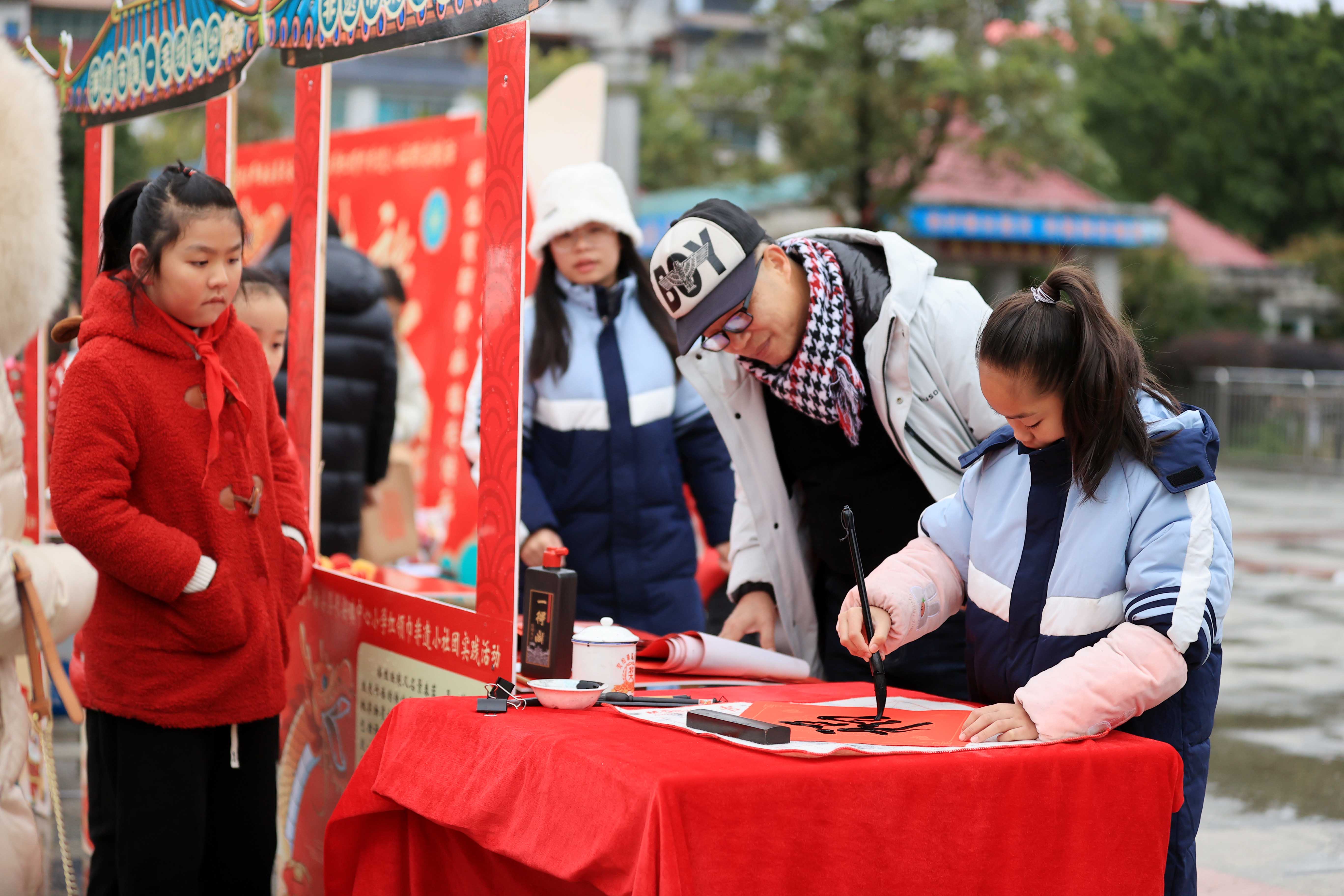 圖10：1月20日，在廣西柳州市融安縣長(zhǎng)安廣場(chǎng)，一名小學(xué)生在書(shū)寫(xiě)福字，準(zhǔn)備贈(zèng)送市民。（譚凱興 攝）.JPG