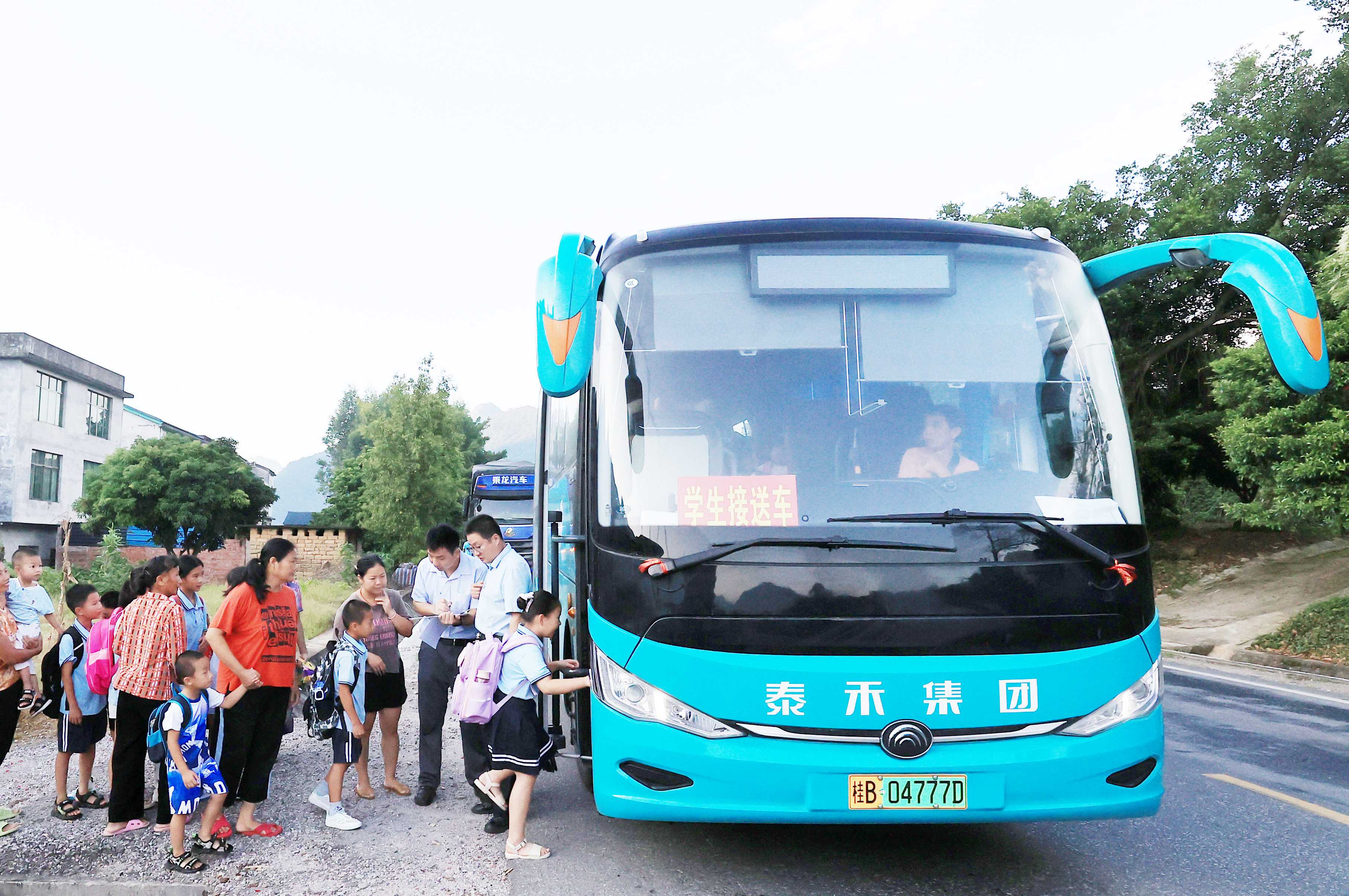 圖2：9月2日早晨，在廣西柳州市融安縣浮石鎮(zhèn)諫村村，工作人員在核對(duì)乘車人員名單，準(zhǔn)備送學(xué)生去學(xué)校讀書。（譚凱興 攝）.JPG